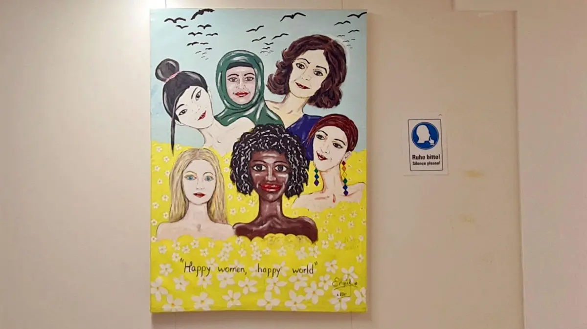 „Happy women, happy world“ – wenn es nur so einfach wäre. In der Erstaufnahmestelle in Tübingern dürfen keine Menschen fotografiert werden. Menschen leben dort aber viele, Frauen, die so vielfältig unterschiedlich sein können wie auf dem Bild, das sie gemalt haben. Nur glücklich sind sie nicht.
