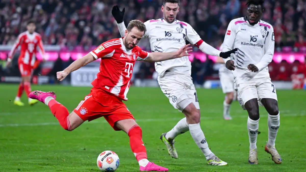 Bayern München - FSV Mainz 05: 14.12.2025, Bayern, München: Fußball: Bundesliga, Bayern München - FSV Mainz 05, 14. Spieltag in der Allianz Arena. Harry Kane (l, Bayern München) und Stefan Bell (M, FSV Mainz 05) und Danny da Costa (FSV Mainz 05) kämpfen um den Ball. Foto: Sven Hoppe/dpa - WICHTIGER HINWEIS: Gemäß den Vorgaben der DFL Deutsche Fußball Liga bzw. des DFB Deutscher Fußball-Bund ist es untersagt, in dem Stadion und/oder vom Spiel angefertigte Fotoaufnahmen in Form von Sequenzbildern und/oder videoähnlichen Fotostrecken zu verwerten bzw. verwerten zu lassen. +++ dpa-Bildfunk +++