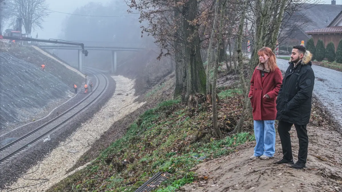 Bahnstrecke nach Zugunglück in Riedlingen: ARCHIV - 09.12.2025, Baden-Württemberg, Riedlingen: Efe Yüksel (l) und Annika Kling, die im Regionalzug der Linie RE 55 saßen, der bei Riedlingen entgleiste, stehen an der Bahnstrecke des tödlichen Zugunglücks. Bei dem Unfall starben drei Menschen, Dutzende wurden verletzt. (zu dpa: «Zugunglück-Trauma lässt Überlebende nicht los») Foto: Jason Tschepljakow/dpa +++ dpa-Bildfunk +++