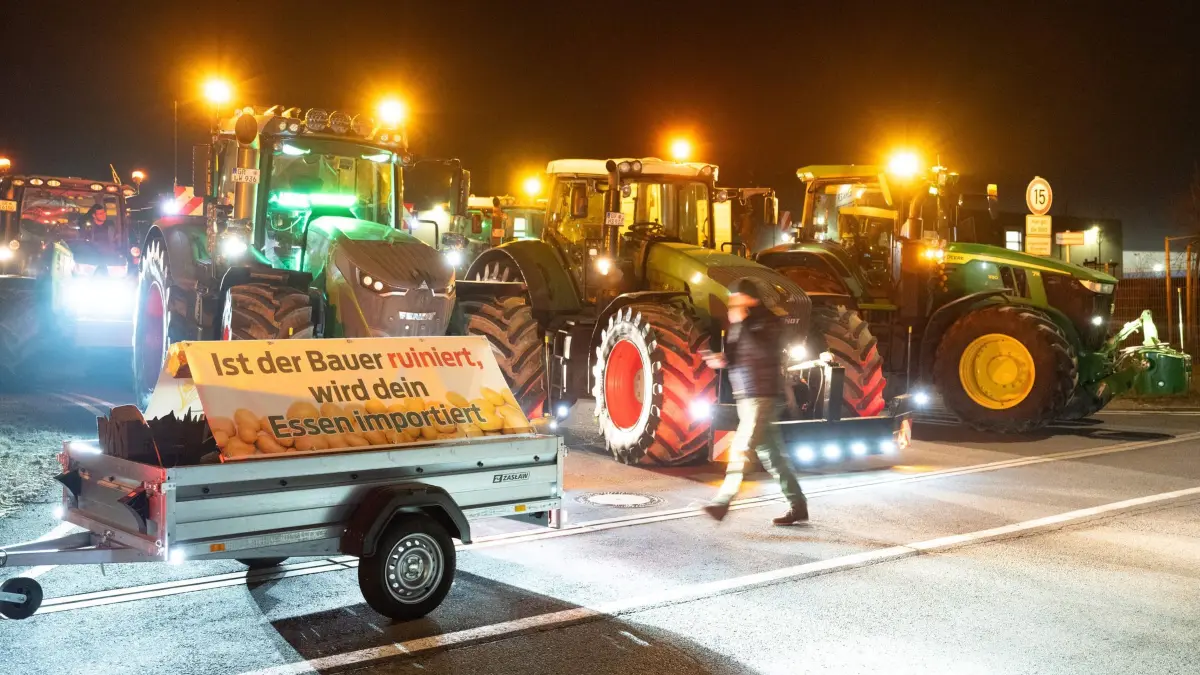 Bauernproteste am LIDL-Logistikknoten: 15.12.2025, Sachsen, Radeburg: Traktoren stehen vor der Einfahrt zu einem LIDL-Logistikzentrum. Anlass sind bundesweite Bauernproteste wegen zu niedriger Milch- und Butterpreise. (zu dpa: «Landwirte protestieren gegen Preispolitik der Discounter») Foto: Sebastian Kahnert/dpa +++ dpa-Bildfunk +++