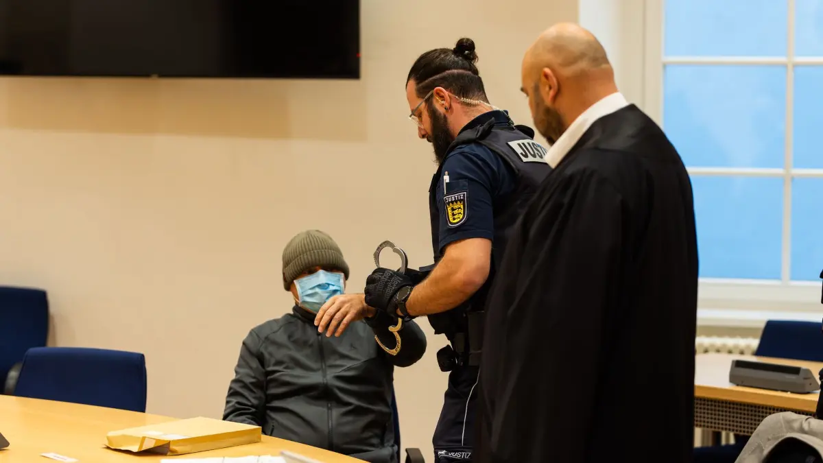 Prozess wegen Totschlags: ARCHIV - 14.10.2024, Baden-Württemberg, Waldshut-Tiengen: Ein Justizbeamter (M) nimmt einem Angeklagten (l) im Gerichtssaal die Handschellen ab, während dessen Verteidiger Waldemar Efimow daneben steht. Der 58-jährige Tatverdächtige soll einen 38-jährigen nach einem Streit erschossen haben, teilte die Staatsanwaltschaft Waldshut-Tiengen mit. Tage später soll er den Toten mit einer Machete in mehrere Teile zerlegt, diese in Maschendraht eingewickelt und an unterschiedlichen Stellen in den Rhein geworfen haben. (zu dpa: «Zerstückelte Leiche im Rhein: Darum wird am BGH verhandelt») Foto: Philipp von Ditfurth/dpa +++ dpa-Bildfunk +++