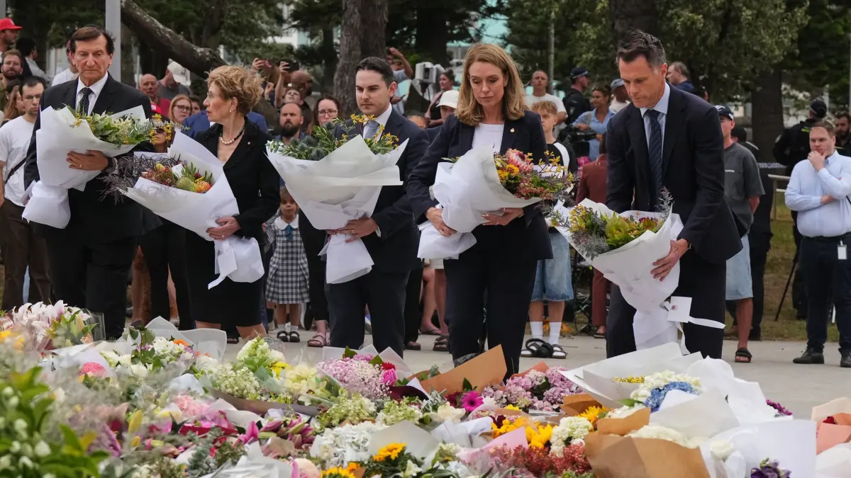Nach Angriff am Bondi Beach: 15.12.2025, Australien, Sydney: Der Premierminister von New South Wales, Chris Minns, rechts, und Kellie Sloane, Vorsitzende der oppositionellen New South Wales Liberal Party, legen einen Tag nach dem Angriff Kränze zum Gedenken an die Opfer des Anschlags vor dem Bondi Pavilion am Bondi Beach in Sydney nieder. Foto: Mark Baker/AP/dpa +++ dpa-Bildfunk +++