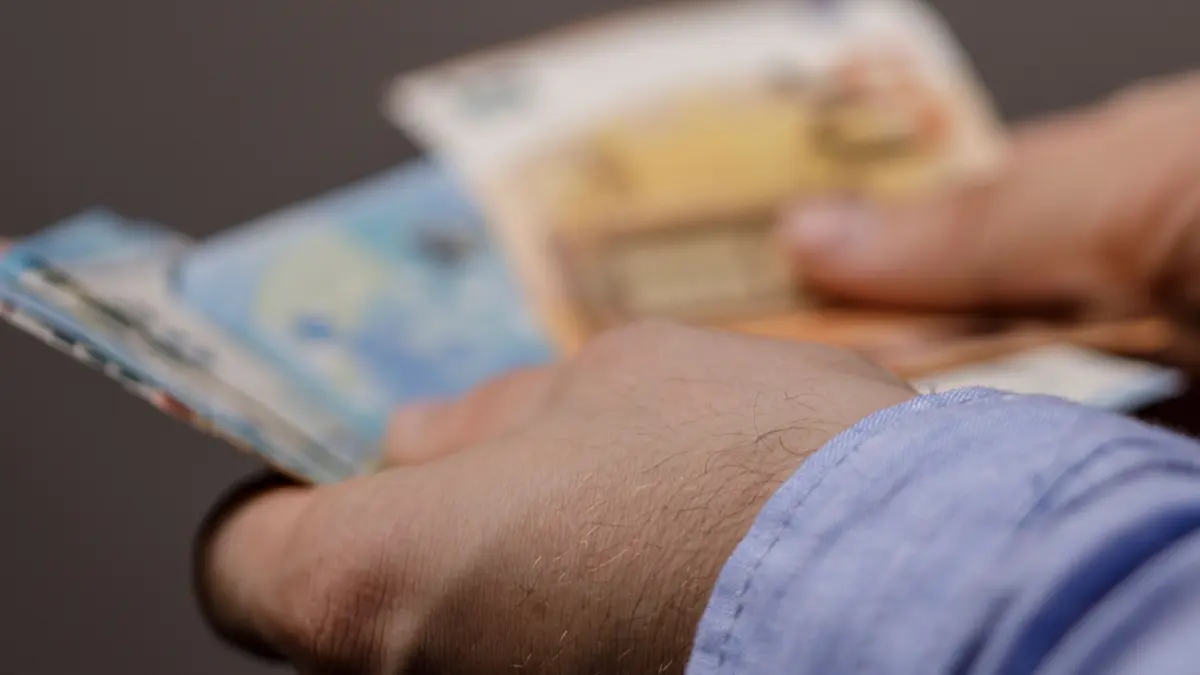 ZU BEACHTEN: NPG-erweiterte Lizenz, Mann hält Geldscheine in den Händen, Download am 17.12.2025 für SWUM, Bildnr. 1766091633