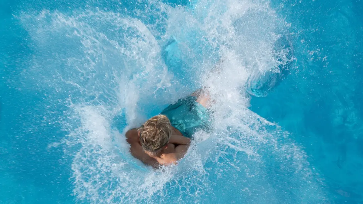 Sprung ins Schwimmbecken (Symbolbild): ARCHIV - 19.08.2023, Sachsen, Dresden: Ein Junge springt im Freibad vom 5-Meter-Turm ins Wasser. (zu dpa: «Neues Lagunen-Erlebnisbad in Willingen steht vor Eröffnung») Foto: Sebastian Kahnert/dpa +++ dpa-Bildfunk +++