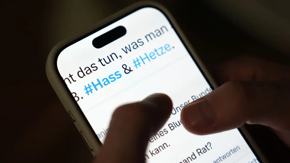 Hass und Hetze in Sozialen Netzwerken: ILLUSTRATION - 26.11.2025, Hamburg: Auf dem Bildschirm eines Smartphones sind in einem Beitrag eines sozialen Netzwerks die Hashtags #Hass und #Hetze zu sehen. Der Begriff wird häufig im Zusammenhang mit digitaler Gewalt und der Verbreitung abwertender Inhalte online verwendet. (zu dpa: «Hessen stellt Meldestelle gegen Hetze im Netz neu auf») Foto: Marcus Brandt/dpa +++ dpa-Bildfunk +++