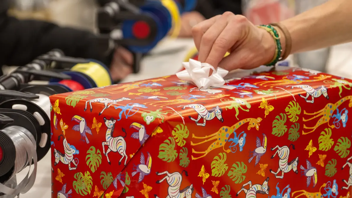 In einem Kaufhaus verpackt eine Verkäuferin für Kunden ein Weihnachtsgeschenk. Der Handelsverband zog zum zweiten Adventssamstag Bilanz. +++ dpa-Bildfunk +++
