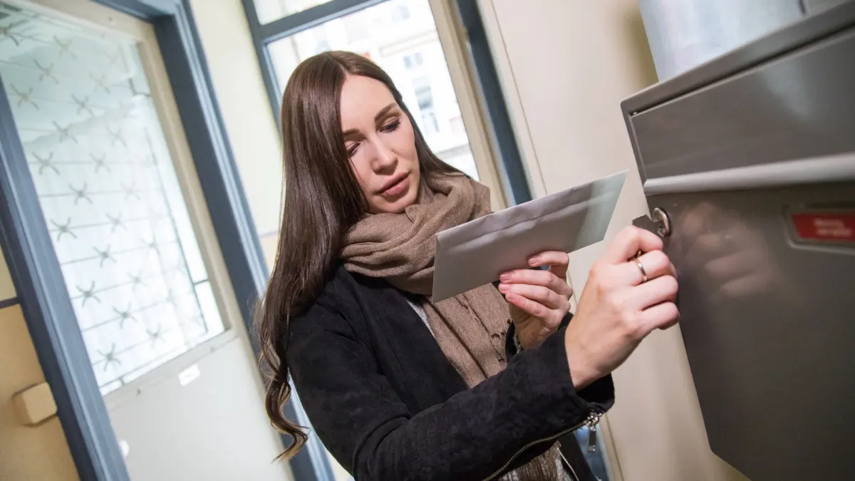 Eine Frau holt einen Brief aus dem Briefkasten: ILLUSTRATION - Post aus dem Briefkasten wirkt oft vertrauenswürdig – doch gefälschte Bank- und Paketbenachrichtigungen mit QR-Codes machen derzeit die Runde. (zu dpa: «Vorsicht Fälschung: Gefährliche QR-Codes im Briefkasten») Foto: Christin Klose/dpa-tmn - Honorarfrei nur für Bezieher des dpa-Themendienstes +++ dpa-Themendienst +++