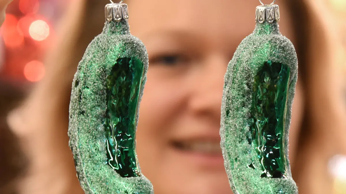 Alexandra Häder hält in ihrer Keramikscheune in Spickendorf bei Halle Glasgurken als Weihnachtsbaumschmuck in ihren Händen. In den USA ist es ein weitverbreiteter Brauch, die sogenannte „Christmas Pickle“ als letztes Baumschmuckstück etwas versteckt in die Zweige zu hängen. Wer sie zuerst findet der erhält ein zusätzliches Weihnachtsgeschenk und viel Glück im kommenden Jahr. (zu dpa: «Von Kugeln und Gurken - so feiern Politiker und Promis») +++ dpa-Bildfunk +++