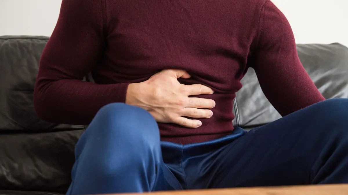 Ein Mann fasst sich mit der Hand an den Bauch: ILLUSTRATION - Uff, Gans und Knödel liegen schwer im Magen! So verlockend das Sofa nun auch ist - ein Spaziergang kommt der Verdauung nun mehr entgegen. (zu dpa: «Völlegefühl bis Brandwunde: Hilfe bei Weihnachts-Wehwehchen») Foto: Christin Klose/dpa-tmn - Honorarfrei nur für Bezieher des dpa-Themendienstes +++ dpa-Themendienst +++