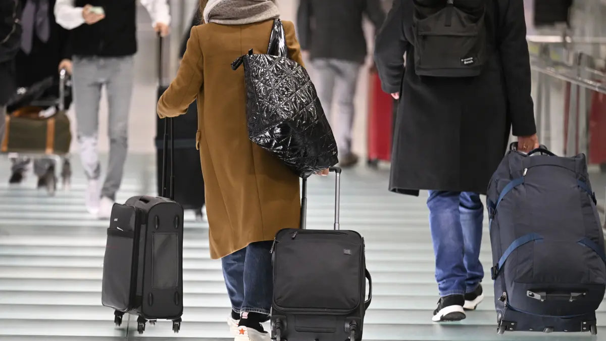 Passagiere gehen zu dem Check-In im Flughafen Köln/Bonn. Am ersten Tag der Weihnachtsferien erwarten Experten ein erhöhtes Verkehrsaufkommen. (zu dpa: «Lange Schlangen nach Technikausfall an deutschen Flughäfen») +++ dpa-Bildfunk +++