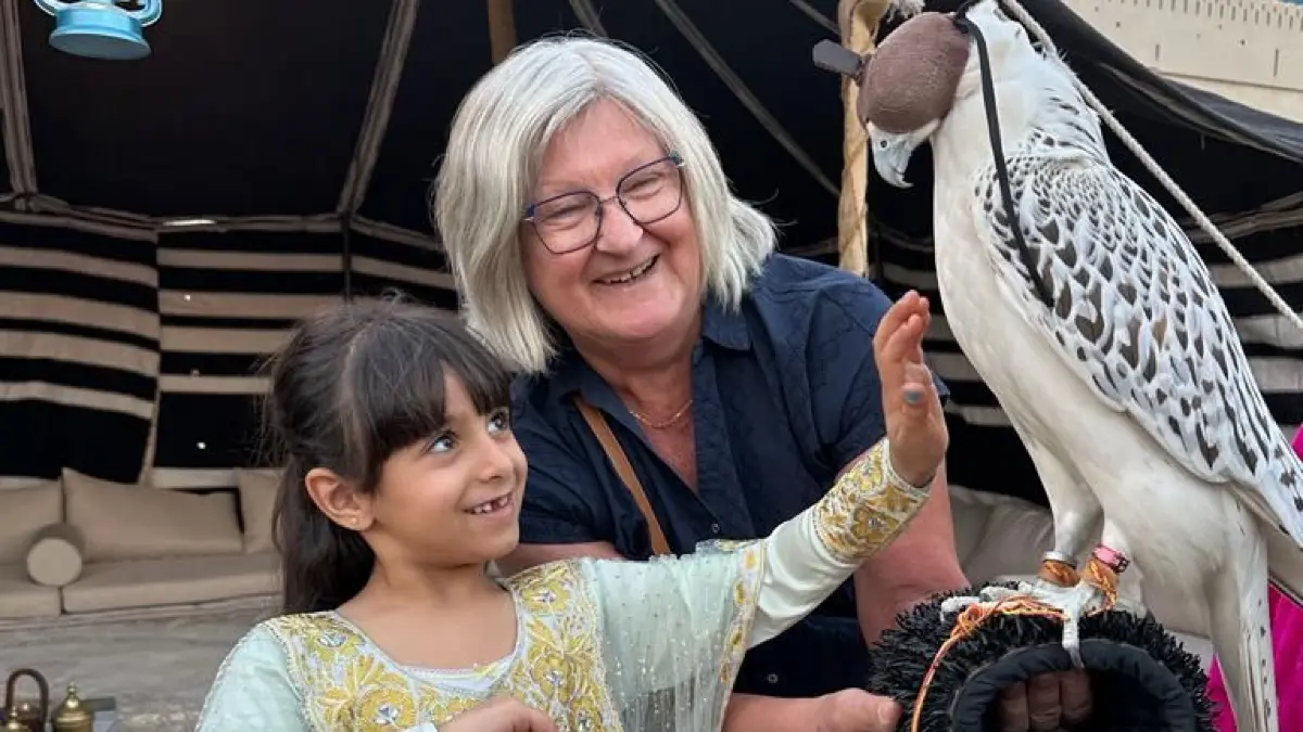 Monika Lisch mit einem ihrer Au-Pair-Kinder und einem Falken in der Wüste in Abu Dhabi.
