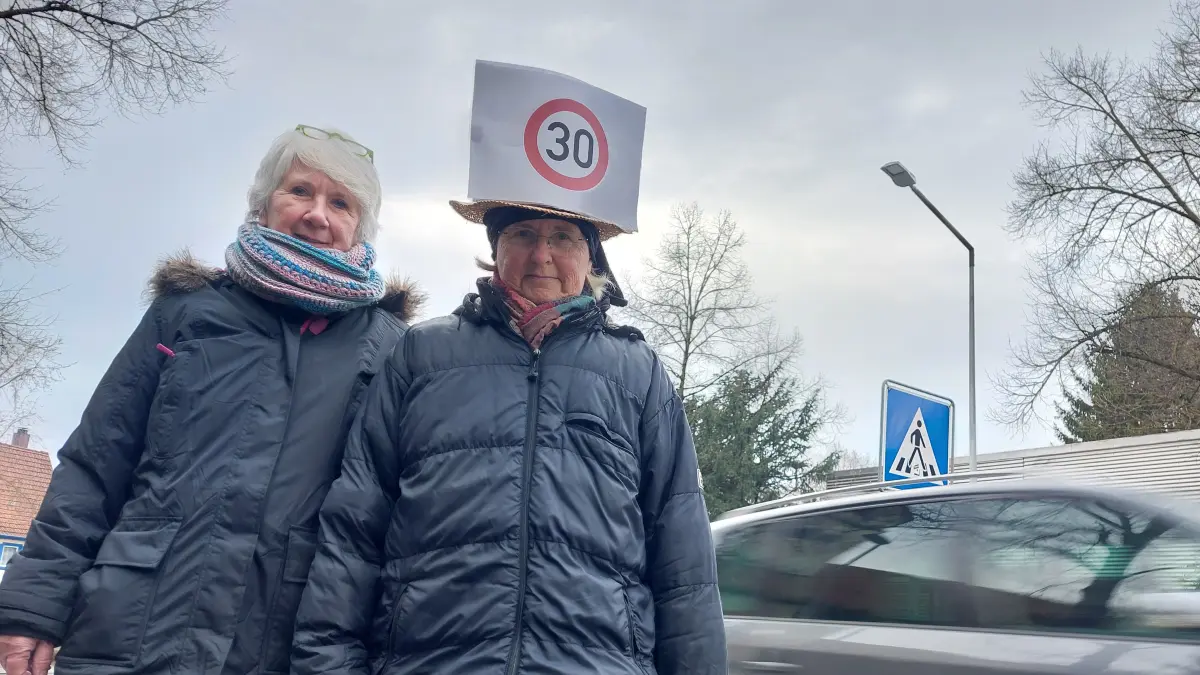 Die Anwohnerinnen Ursula Schaller (links) und Johanna Dürr mit einem Protesthut für Tempo 30 in Bezgenriet am Zebrastreifen.