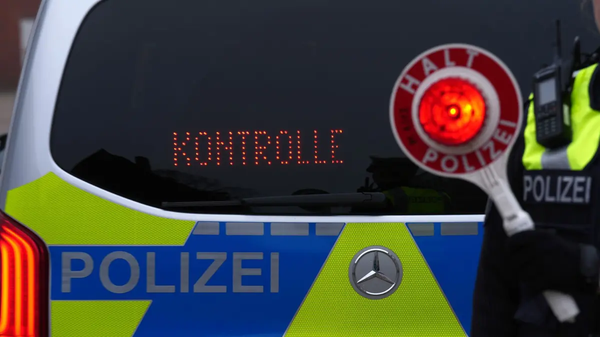 Polizeikontrolle: ARCHIV - 11.12.2024, Schleswig-Holstein, Kiel: Eine Polizistin hält eine Anhaltekelle vor den Schriftzug „Kontrolle“ an der Heckscheibe des Einsatzfahrzeugs auf dem Gelände des Polizeizentrums Eichhof. (zu dpa: «Junger Mann schleicht mit Radlader über Autobahn») Foto: Marcus Brandt/dpa +++ dpa-Bildfunk +++