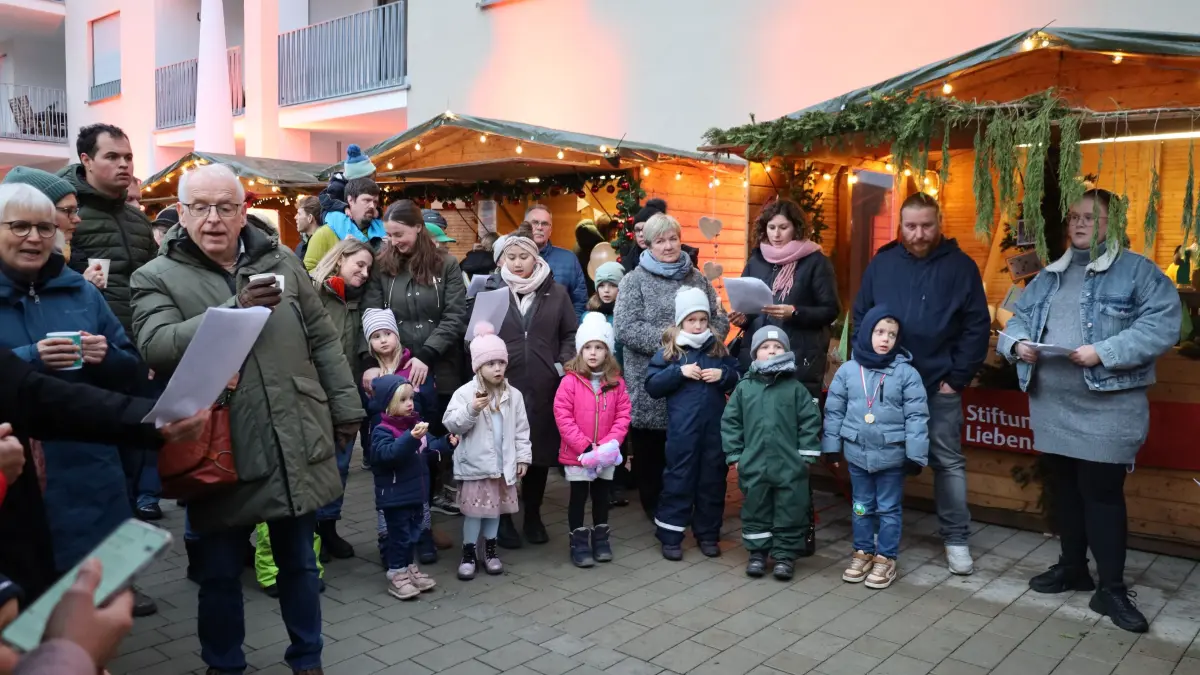 Die Kinder singen zusammen mit den Erwachsenen klassische und moderne Weihnachtslieder zur Eröffnung des Platzes auf dem ehemaligen DHL-Gelände