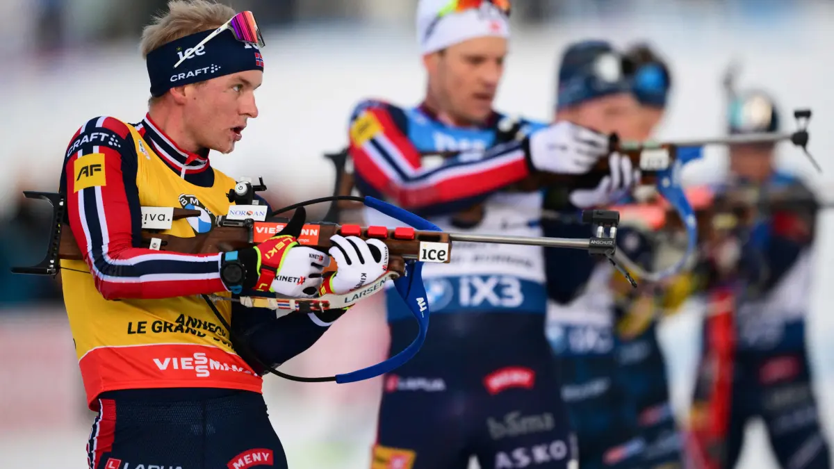 Norway's Johan-Olav Botn (L) reacts during the men's 15km mass start event of the IBU Biathlon World Cup, in Le Grand Bornand, near Annecy, southeastern France, on December 21, 2025. (Photo by Olivier CHASSIGNOLE / AFP)