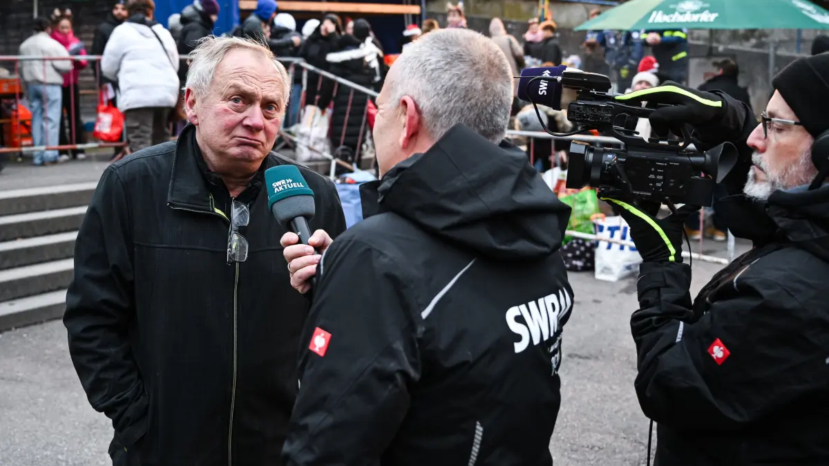 Heiligabend - Markt, Weihnachten schenken: Horb (Kreis Freudenstadt) 23.12.2025
SWR Reporter Harry Roehrle (Mitte) im Gespraech mit Organisator Rolf Maier (li) auf dem Heiligabend - Markt, Weihnachten schenken, im Schulhof der Gutermann - Grundschule in der Innenstadt.
FOTO: Pressefoto ULMER / Markus UlmerxxNOxMODELxRELEASExx