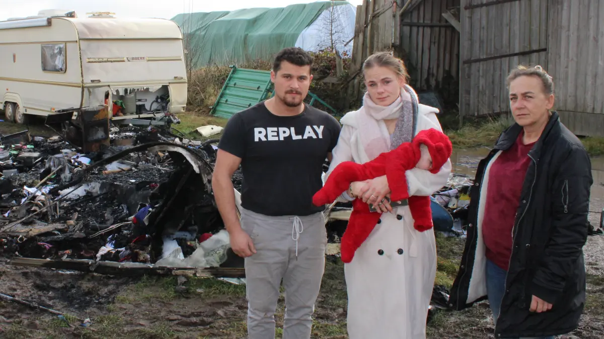 Die Artistenfamilie steht vor den Trümmern des Wohnwagens und weiß nicht, wie es weitergehen soll. Links im Bild: Hündin Stella, die noch nicht fassen kann, was passiert ist. Diana Frank (rechts) mit ihrer Tochter Angelina Prinzler, Baby Levana und Schwiegersohn Micel Quaiser.