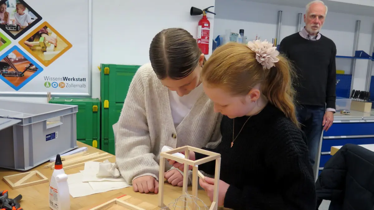 Clara (links) und Sofie sind in den Räumen der Wissenswerkstatt Zollernalb in die Arbeit vertieft. Mit ihrem Projekt, das den Arbeitstitel „Erdbebensicherheit“ trägt, liegen sie gut im Zeitplan (im Hintergrund Betreuer Dr. Thomas Bregel).