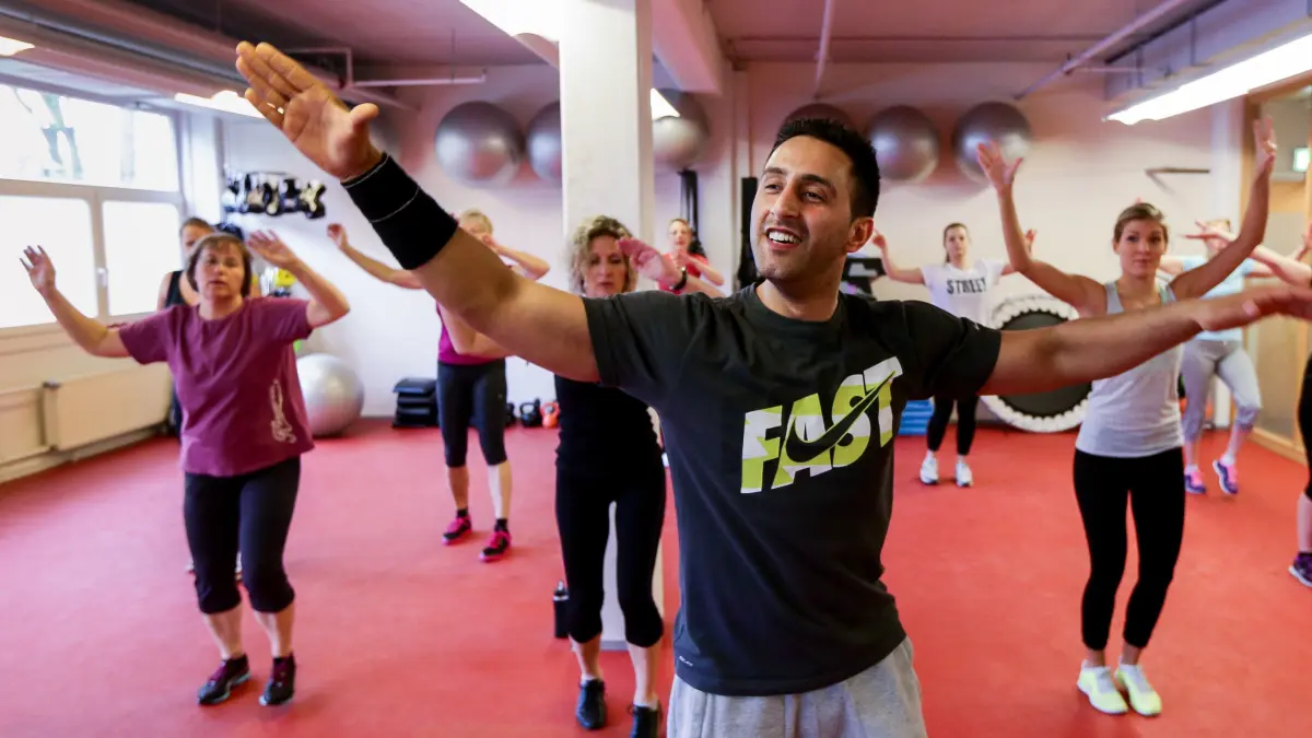 Mitarbeiter der Otto Group in Hamburg nehmen in ihrer Mittagspause am 24.04.2014 an einem "Zumba"-Kurs mit Kursleiter Dilava Singh (vorn) teil. Ein Drittel der Hamburger Firmen haben ein Betriebliches Gesundheitsmanagement (BGM) eingeführt, um die Gesundheit und Arbeitsfähigkeit der Mitarbeiter zu fördern. Foto: Ulrich Perrey/dpa (zu KORR "Mit Gesundheitsförderung «alte Eisen» und Job-Nachwuchs sichern" vom 28.04.2014)