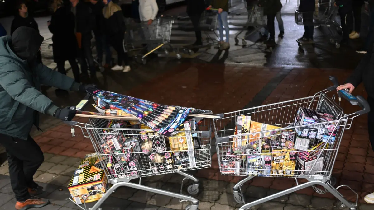Feuerwerk: ARCHIV - 28.12.2023, Niedersachsen, Bunde: Junge Niederländer sind extra angereist, um zu Beginn des Verkaufs von Silvesterfeuerwerk bei einem Discounter in der Grenzregion deutsches Feuerwerk einzukaufen. (zu dpa: «Niederländer böllern zum letzten Mal») Foto: Lars Penning/dpa +++ dpa-Bildfunk +++