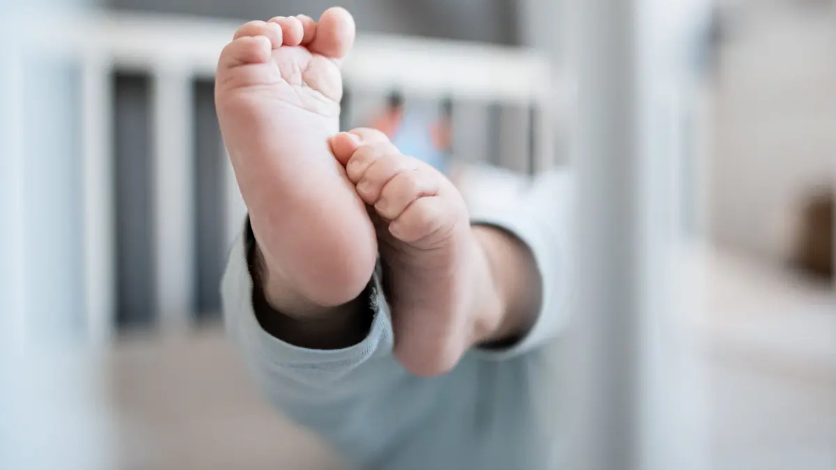Illustration - Vornamen: ARCHIV - 30.12.2019, Nordrhein-Westfalen, Oberhausen: Die Füße eines Babys sind in einem Kinderbett zu sehen. (zu dpa: «Diese Namen wurden in Sachsen-Anhalt am häufigsten vergeben») Foto: Fabian Strauch/dpa +++ dpa-Bildfunk +++