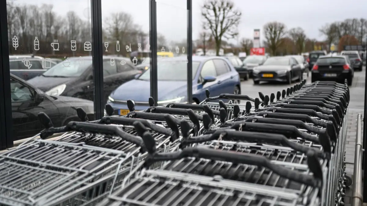 Silvester 2025 - Leer: 31.12.2025, Niedersachsen, Leer: Zahlreiche Einkaufswagen und PKW stehen auf einem Supermarkgelände. Regnerisches und windiges Wetter wird in Niedersachsen zum Jahreswechsel vorhergesagt. Foto: Lars Penning/dpa +++ dpa-Bildfunk +++