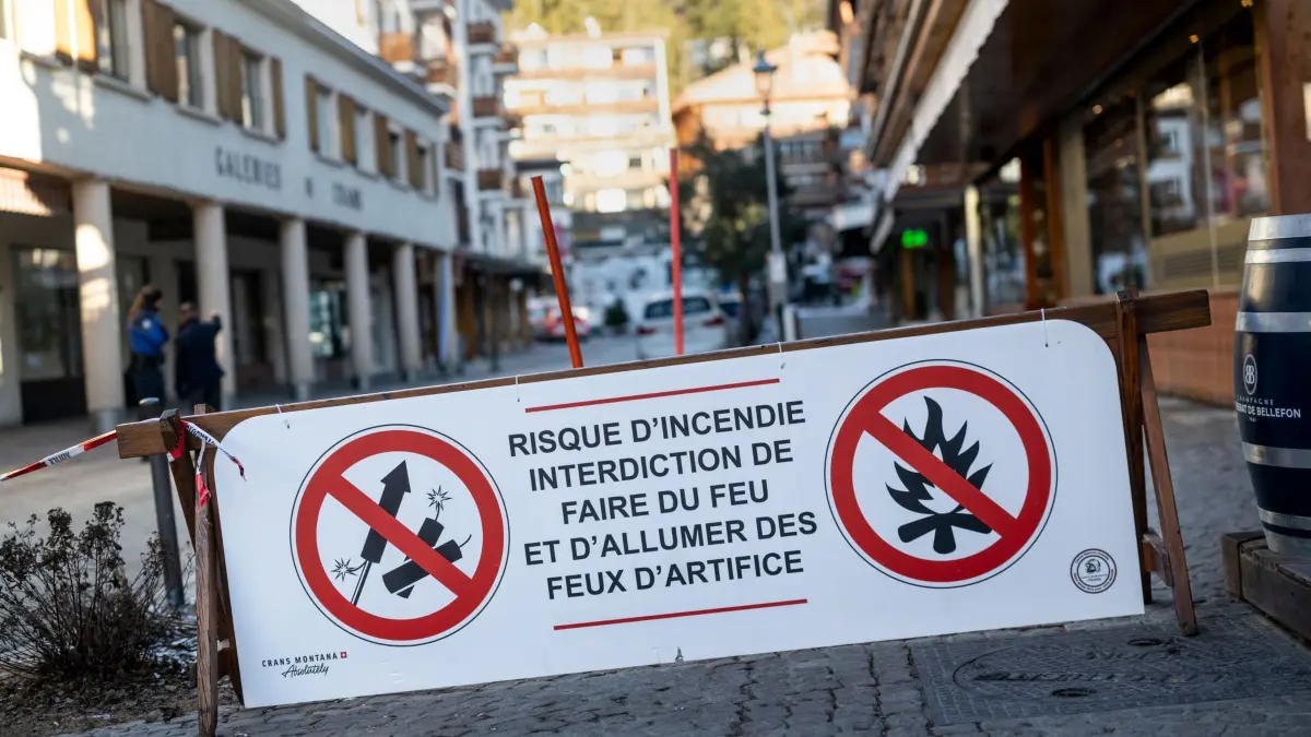 Explosion bei Silvesterparty in Skiort in der Schweiz: 01.01.2026, Schweiz, Crans-Montana: Ein Banner mit dem Hinweis, dass Feuerwerkskörper wegen Brandgefahr verboten sind, ist in der Nähe des Bereichs abgebildet, in dem in der Bar und Lounge Le Constellation nach einer Explosion in den frühen Morgenstunden der Silvesternacht ein Feuer ausgebrochen ist. Bei einer Explosion und einem Brand in der Silvesternacht sind im noblen Schweizer Skiort Crans-Montana nach Polizeiangaben mehrere Menschen ums Leben gekommen. Foto: Alessandro Della Valle/KEYSTONE/dpa +++ dpa-Bildfunk +++