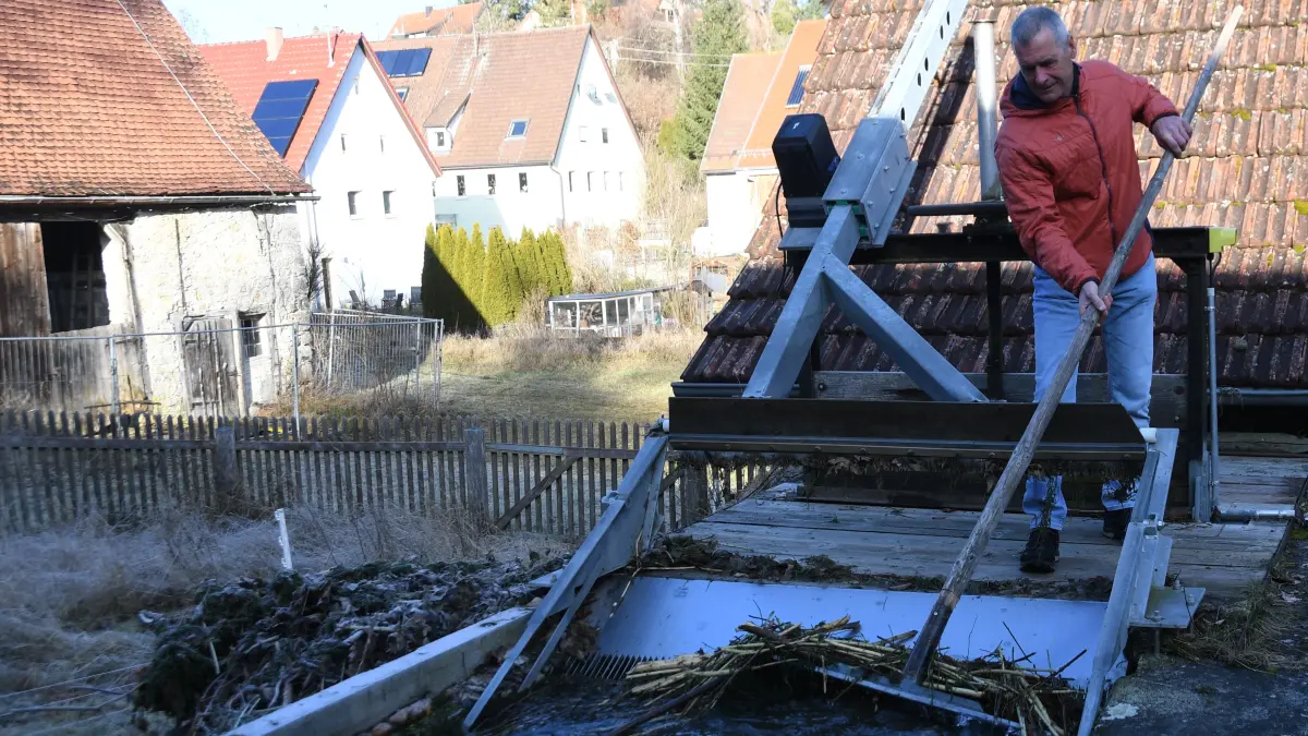 Horst Rainer entfernt vom Biber angehäuftes Gestrüpp am Zugang des Wasserkraftwerks in Offenhausen.