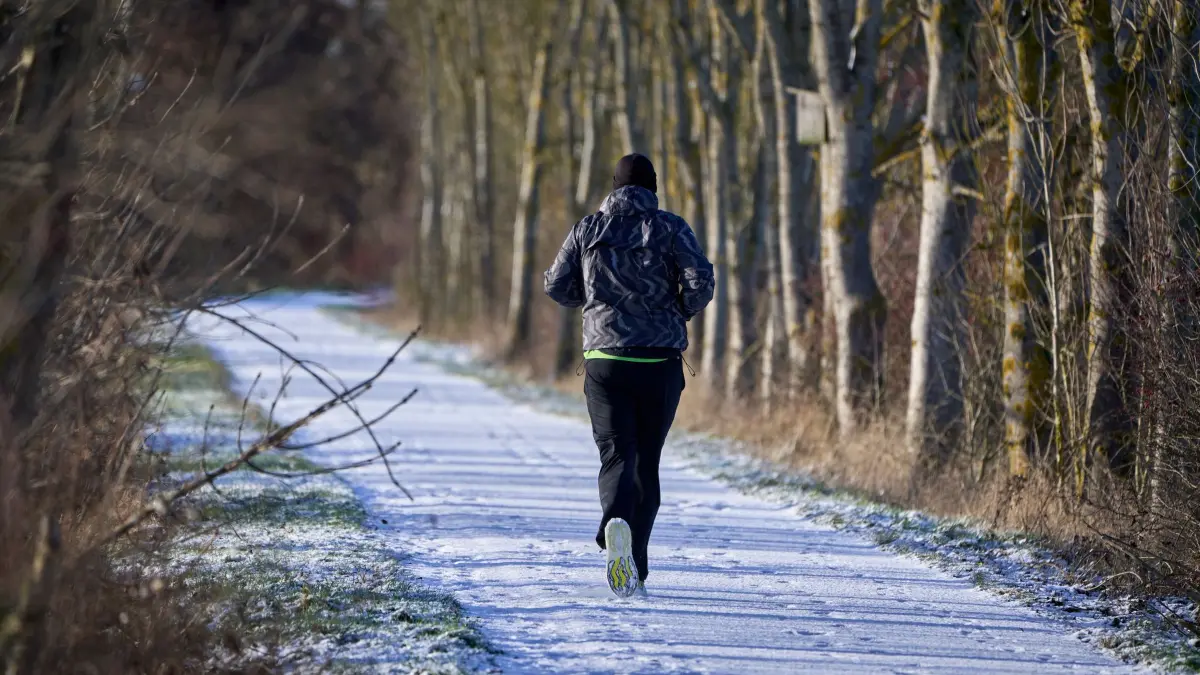Winterwetter in Rheinland-Pfalz: 02.01.2026, Rheinland-Pfalz, Gierschnach: Ein Freizeitsportler joggt durch die Winterlandschaft auf dem Maifeld, nahe Gierschnach im Landkreis Mayen-Koblenz. Foto: Sascha Ditscher/dpa +++ dpa-Bildfunk +++