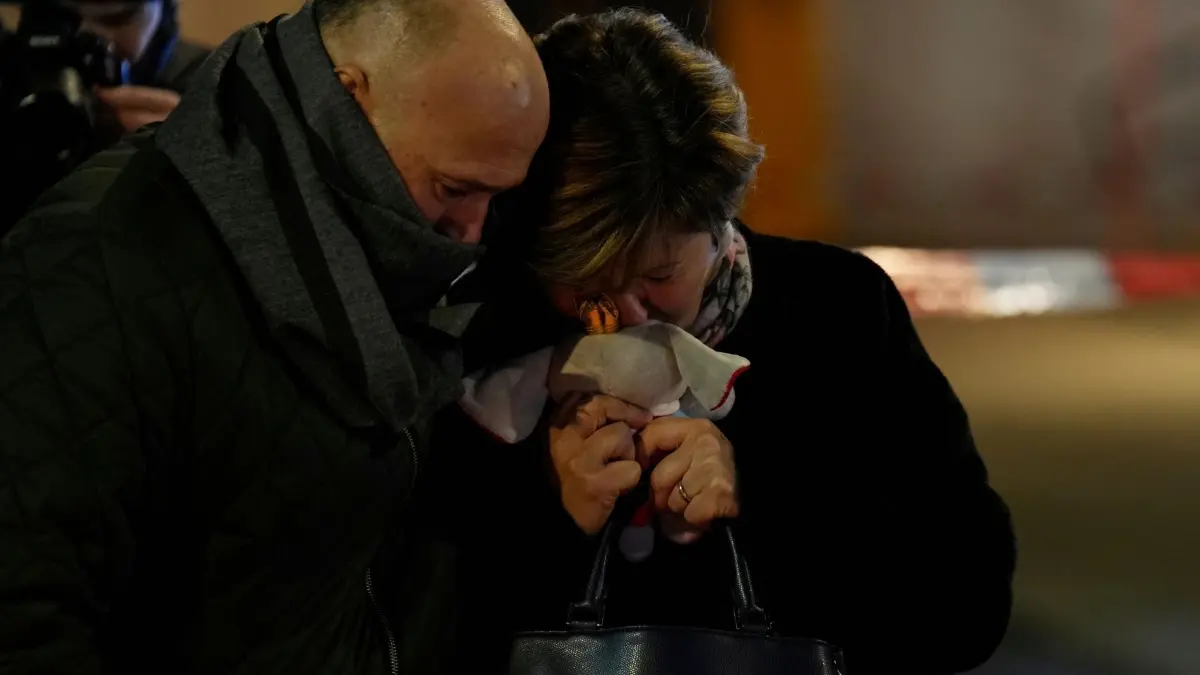 Tote bei Silvesterparty in Crans-Montana: 02.01.2026, Schweiz, Crans-Montana: Eine Frau mit einem Stofftier in der Hand, deren Tochter vermisst wird, steht in der Nähe der abgeriegelten Bar Le Constellation, wo ein verheerender Brand während der Silvesterfeierlichkeiten Tote und Verletzte forderte. Foto: Baz Ratner/AP/dpa +++ dpa-Bildfunk +++