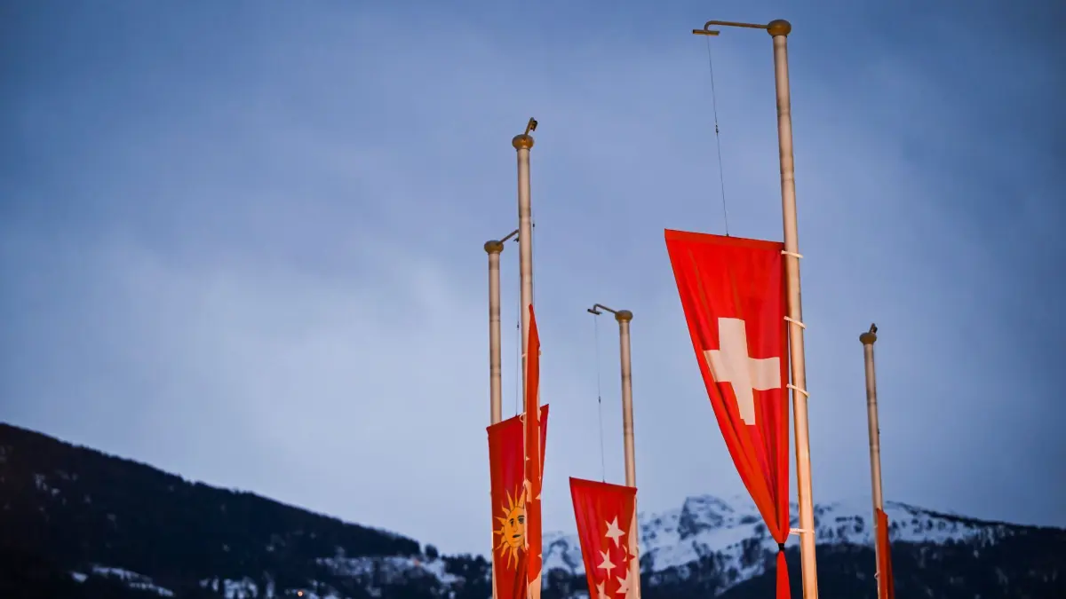 Tote bei Silvesterparty in Crans-Montana: 02.01.2026, Schweiz, Sierre: Die Flaggen der Schweiz und des Kantons Wallis wehen auf Halbmast. Bei einem Brand in der Bar Le Constellation in Crans-Montana kamen in der Silvesternacht mehrere Menschen ums Leben. Foto: Jean-Christophe Bott/KEYSTONE/dpa +++ dpa-Bildfunk +++