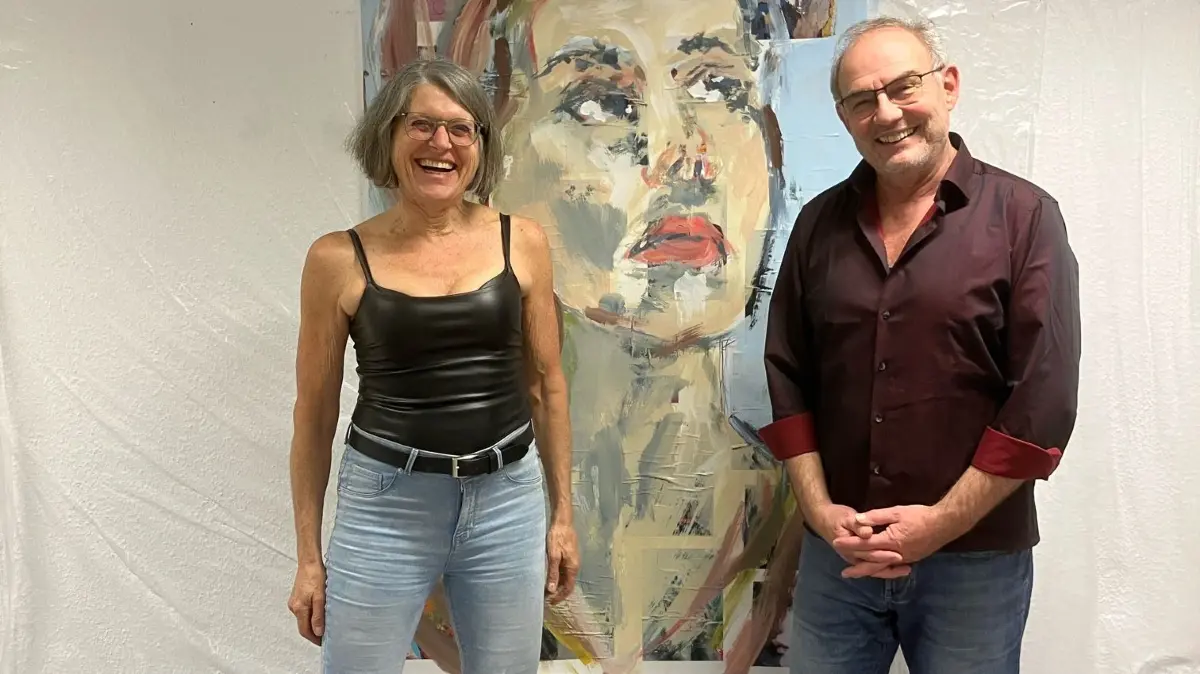 Christiane Walz und Andreas Harthan vor einem Bild, das der Künstler Kim Helbig, Kunsterzieher am Albert-Schweitzer-Gymnasium, im Rahmen einer Performance am letzten Tag des Kulturwerks gemalt hat.