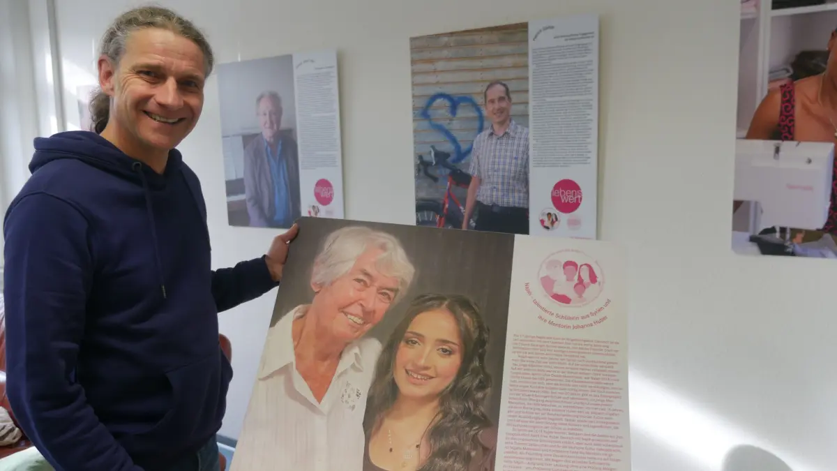 Dr. Gernot Bohnenberger zeigt sich begeistert vor einer Ausstellung von Ringelbach-Bewohnern, die sich in dem Reutlinger Quartier mit Hilfe von "Hallo Nachbarn" für andere Menschen einsetzen.