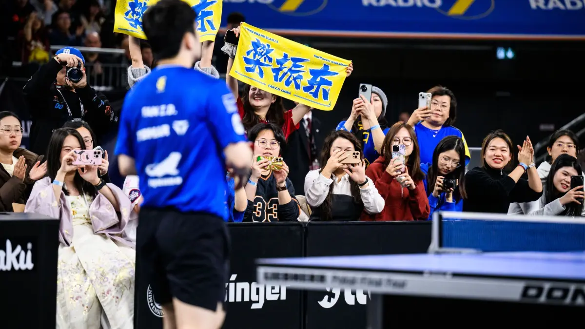Tischtennis: Liebherr Pokal-Final Four 2026: 04.01.2026, Bayern, Neu-Ulm: Tischtennis: TTBL-Pokal, Finalturnier, Finale, 1. FC Saarbrücken – TTC Fulda-Maberzell, Fan - Ovtcharov, ratiopharm arena. Fans von Zhendong Fan sitzen neben der Tischtennisplatte und fotografieren Zhendong Fan während des Spiels. Foto: Tom Weller/dpa +++ dpa-Bildfunk +++