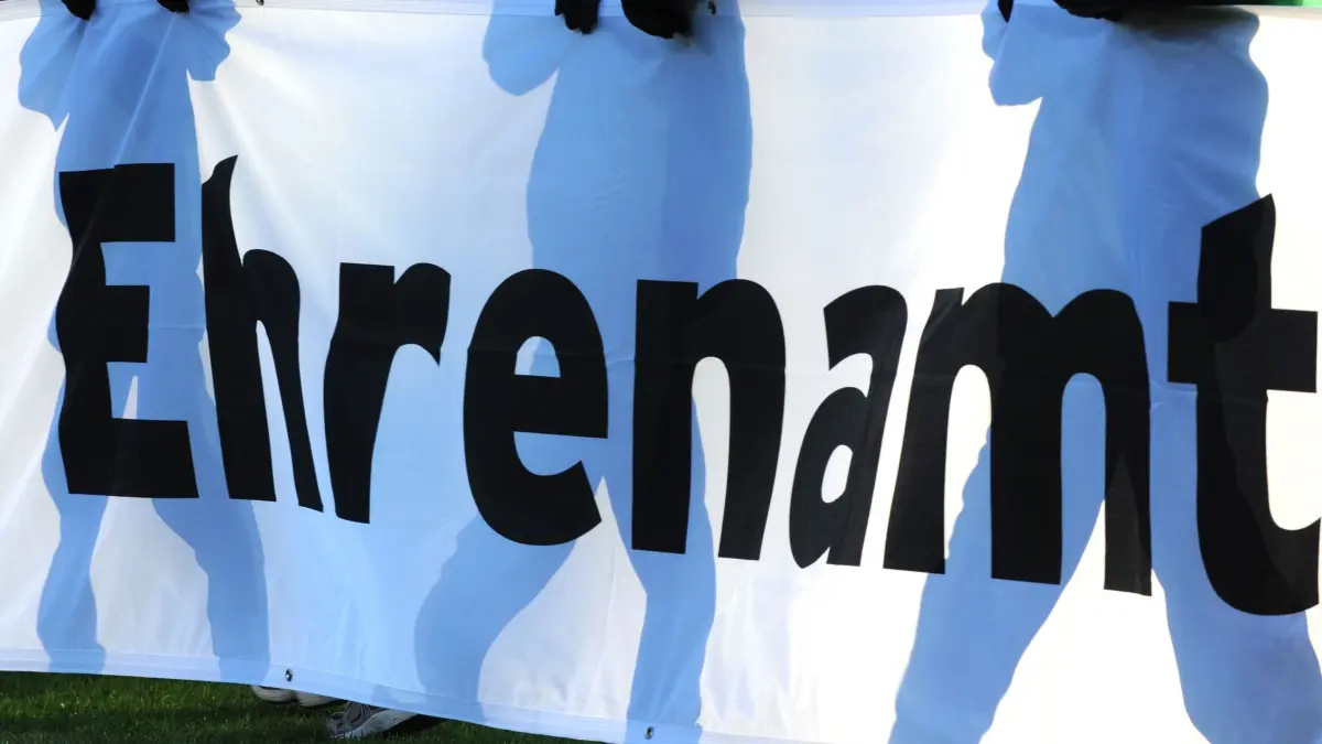 Ehrenamt: ARCHIV - 04.12.2010, Baden-Württemberg, Freiburg: Jugendliche halten vor einem Fußball-Bundesligaspiel ein Banner mit der Aufschrift «Ehrenamt» in den Händen. (zu dpa: «Ehrenamt: Geld für Sportvereine, DRK und Freizeitangebote») Foto: Patrick Seeger/dpa +++ dpa-Bildfunk +++