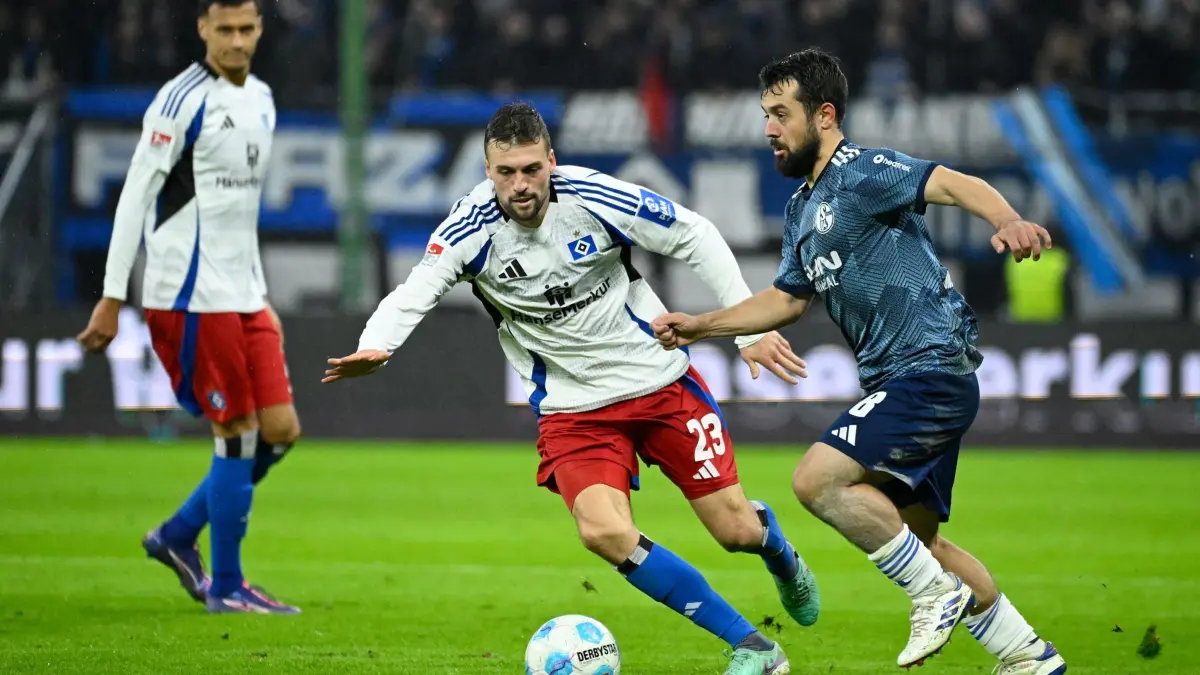 Jonas Meffert (M): ARCHIV - 23.11.2024, Hamburg: Fußball: 2. Bundesliga, Hamburger SV - FC Schalke 04, 13. Spieltag, Volksparkstadion. Hamburgs Jonas Meffert (M) und Schalkes Amin Younes kämpfen um den Ball. (zu dpa: «Meffert vom Bundesliga-Verbleib des HSV überzeugt») Foto: Gregor Fischer/dpa - WICHTIGER HINWEIS: Gemäß den Vorgaben der DFL Deutsche Fußball Liga bzw. des DFB Deutscher Fußball-Bund ist es untersagt, in dem Stadion und/oder vom Spiel angefertigte Fotoaufnahmen in Form von Sequenzbildern und/oder videoähnlichen Fotostrecken zu verwerten bzw. verwerten zu lassen. +++ dpa-Bildfunk +++
