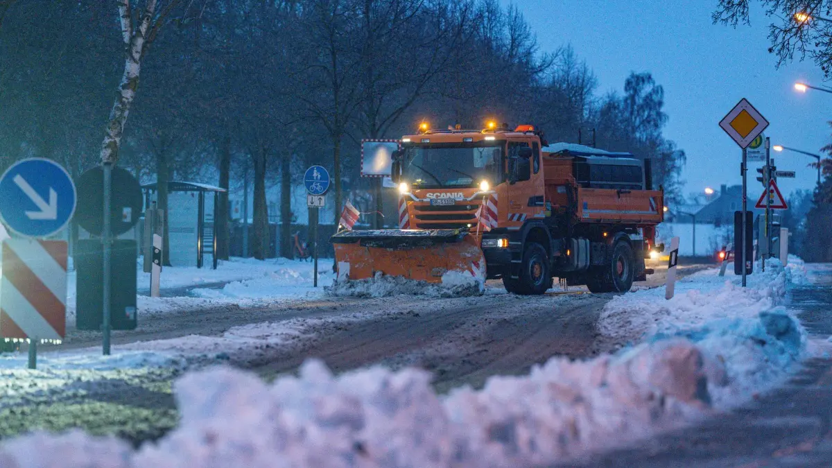 Winterwetter - Sturmtief Elli - Straubing: 09.01.2026, Bayern, Straubing: Ein Räumfahrzeug beseitigt während Eisregens den Schnee auf einer Straße. Sturmtief Elli sorgt bundesweit für Beeinträchtigungen. Foto: Armin Weigel/dpa +++ dpa-Bildfunk +++