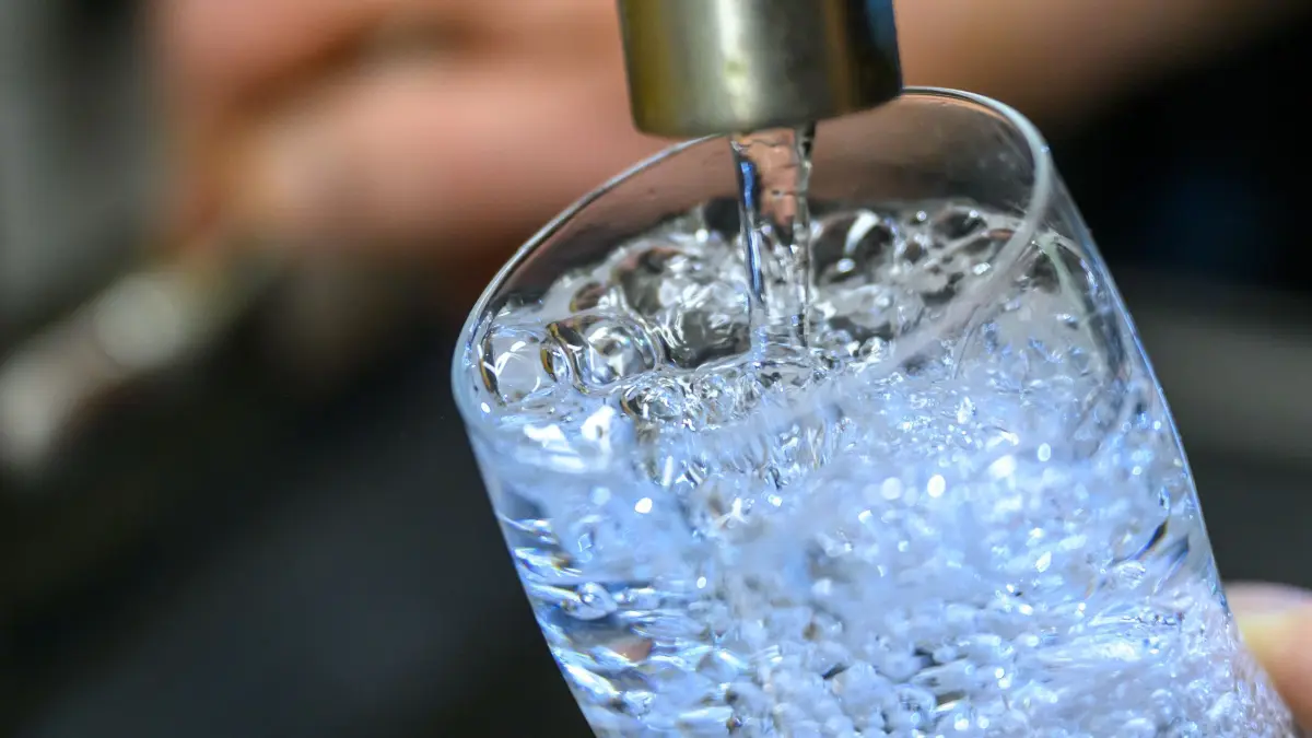 Wasserrohrbruch in Chemnitzer Innenstadt: ARCHIV - 24.07.2025, Sachsen, Chemnitz: Trinkwasser läuft in einer Küche in Chemnitz in ein Glas. 100 Personen in der Chemnitzer Innenstadt bekommen derzeit kein Trinkwasser aus ihrer Leitung. (zu dpa: «Trinkwassertanker versorgt 100 Chemnitzer nach Rohrbruch») Foto: Hendrik Schmidt/dpa +++ dpa-Bildfunk +++