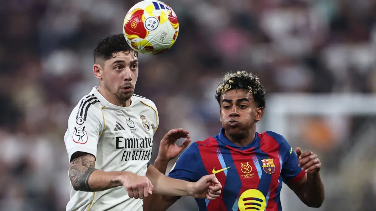 Real Madrid's Uruguayan midfielder #08 Federico Valverde (L) and Barcelona's Spanish forward #10 Lamine Yamal fight for the ball during the Spanish Super Cup final football match between FC Barcelona and Real Madrid at the King Abdullah Stadium in Jeddah on January 11, 2026. (Photo by Fadel SENNA / AFP)