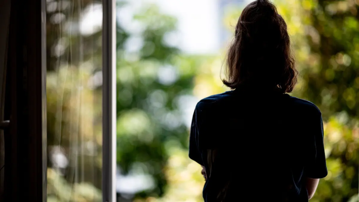 Eine Frau steht an einem offenen Fenster: ILLUSTRATION - 13.07.2021, Berlin: Eine Frau steht an einem offenen Fenster (zu dpa: «Toxische Beziehungen im Rampenlicht») Foto: Fabian Sommer/dpa/dpa-tmn +++ dpa-Bildfunk +++