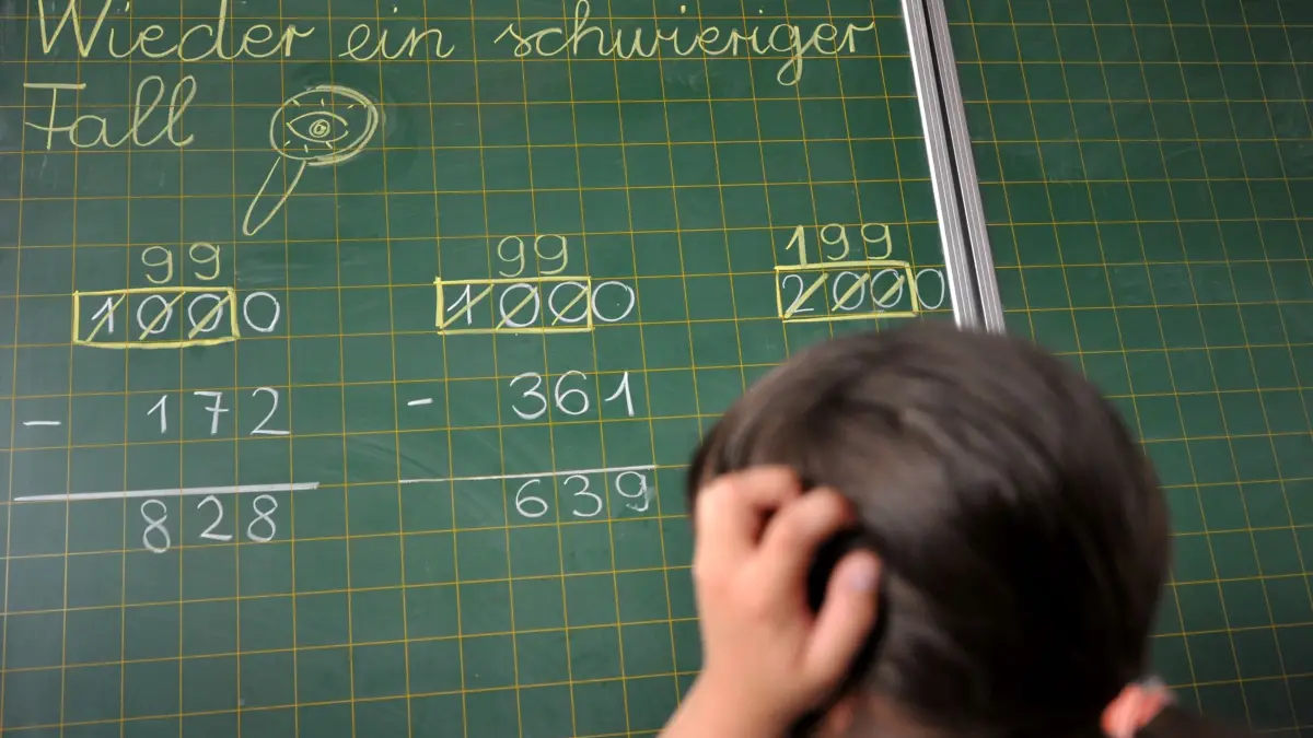 Mathe-Unterricht: ARCHIV - 31.05.2011, Bayern, München: Ein Mädchen der zweiten Klasse der Grundschule steht an der Tafel vor einer Rechenaufgabe. (zu dpa: «Niedersachsen: Schaffen schriftliche Division nicht ab») Foto: Frank Leonhardt/dpa +++ dpa-Bildfunk +++