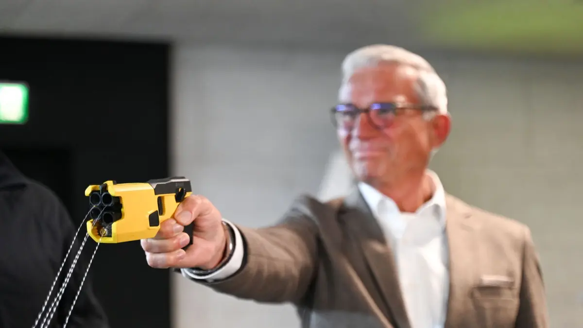Projektstart Taser-Einsatz: 12.01.2026, Baden-Württemberg, Göppingen: Thomas Strobl (CDU), Innenminister von Baden-Württemberg, löst zur Demonstration einen sogenannten Taser im Polizeipräsidium Einsatz in Göppingen aus. Nach zahlreichen anderen Bundesländern sollen nun auch Streifenpolizisten in Baden-Württemberg mit Elektroschockern - sogenannten Tasern - ausgerüstet werden. In dem Pilotprojekt werden zwei unterschiedliche Modelle für jeweils ein Jahr testweise in Südbaden und Göppingen eingesetzt. Foto: Katharina Kausche/dpa +++ dpa-Bildfunk +++