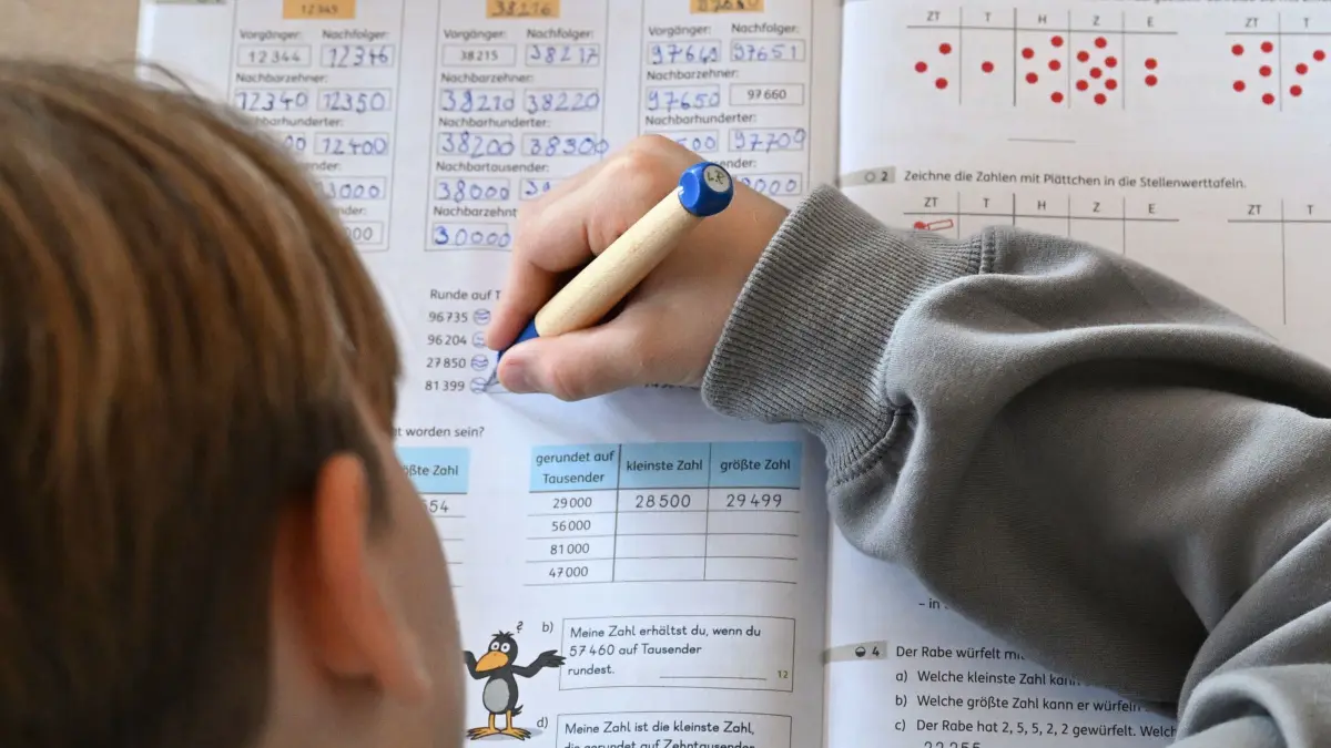 Grundschule: SYMBOLBILD - 05.11.2025, Baden-Württemberg, Stuttgart: In einer Grundschule arbeitet ein Schüler einer vierten Klasse an in einem Heft an seinen Mathematikaufgaben. (zu dpa: «So sollen Grundschüler künftig dividieren») Foto: Bernd Weißbrod/dpa +++ dpa-Bildfunk +++