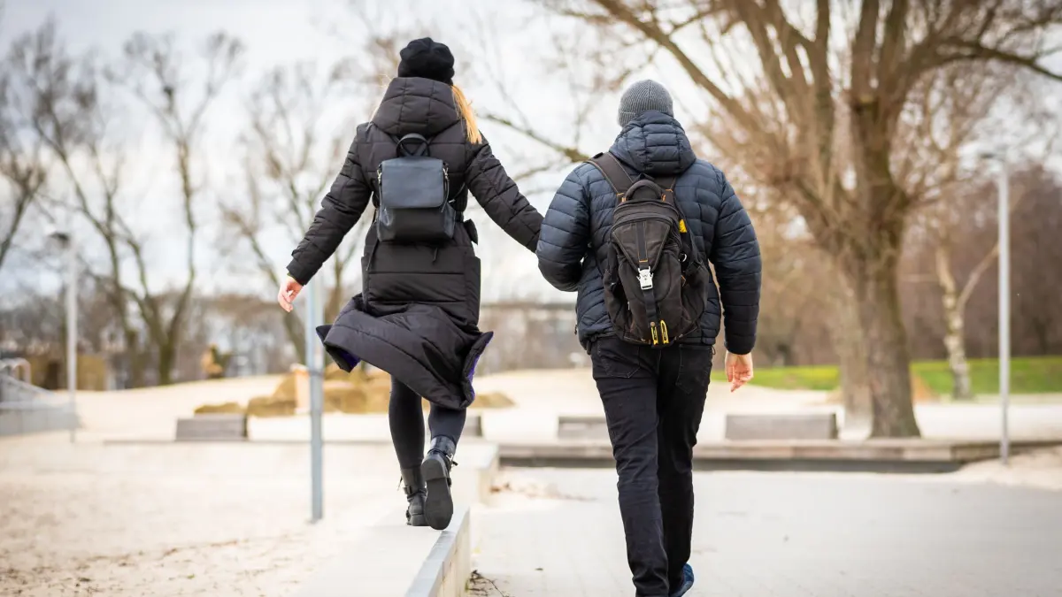 Spaziergänger durchqueren bei trübem Wetter einen Park