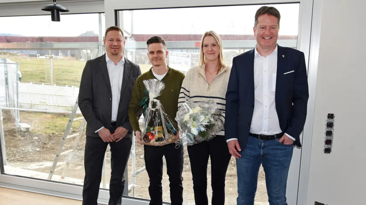 Bürgermeister Philipp Hahn (rechts) und Stadtwerke-Chef Markus Friesenbichler (links) begrüßten die ersten Killberg-IV-Bewohner Sonja und Tim Haug mit Blumen.