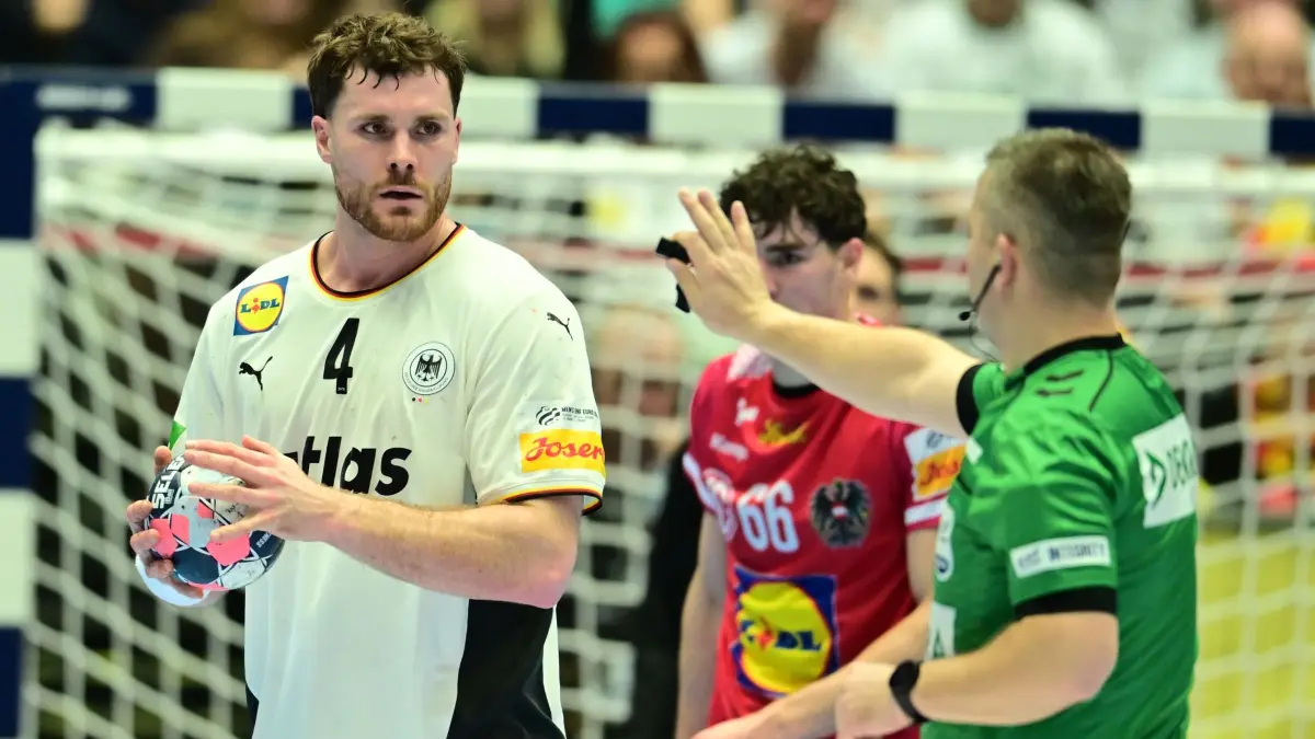 Deutschland - Österreich: 15.01.2026, Dänemark, Herning: Handball: EM, Deutschland - Österreich, Vorrunde, Gruppe A, 1. Spieltag, Jyske Bank Boxen. Schiedsrichter Ivan Pavicevic (Montenegro) spricht zu Johannes Golla (Deutschland). Foto: Sina Schuldt/dpa +++ dpa-Bildfunk +++