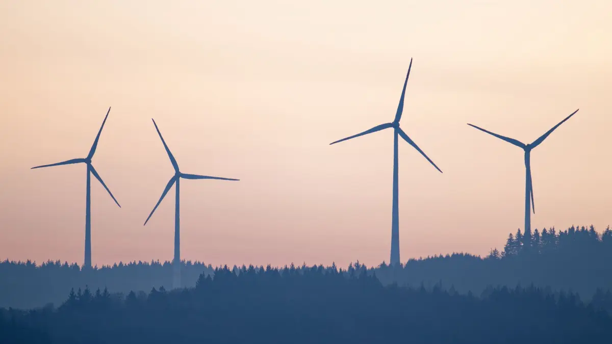 Windkraftanlagen: ARCHIV - 16.12.2025, Baden-Württemberg, Altenbach: Windräder stehen im Licht der aufgehenden Sonne auf einem Hügel des Odenwalds. (zu dpa: «Kommunen verdienen an Windstrom - bald mehr?») Foto: Uwe Anspach/dpa +++ dpa-Bildfunk +++