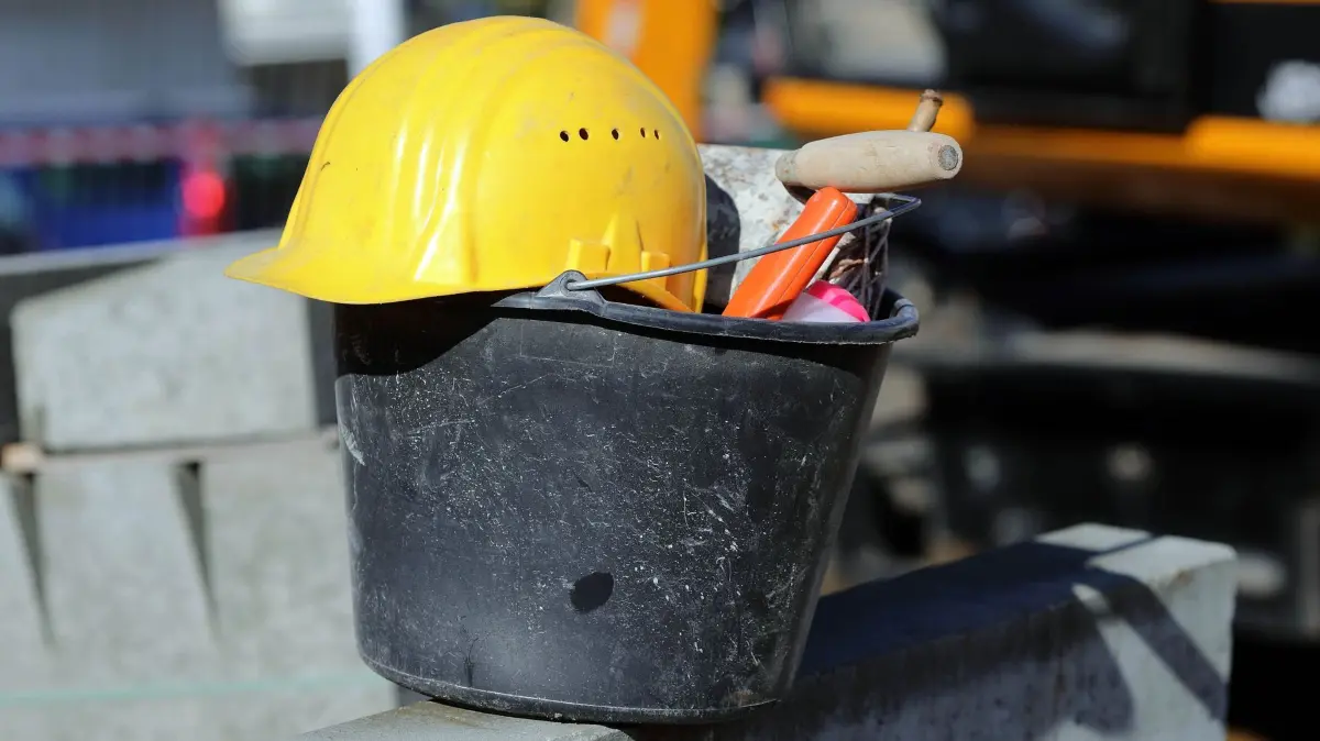 Arbeitsschutz: ARCHIV - 15.10.2012, Sachsen-Anhalt, Magdeburg: Ein Helm liegt auf einem Eimer eines Bauarbeiters. (zu dpa: «2025 verzeichnet das Lagus fünf tödliche Arbeitsunfälle») Foto: Jens Wolf/dpa-Zentralbild/dpa +++ dpa-Bildfunk +++