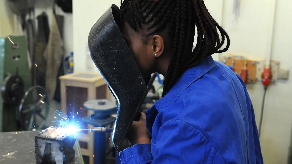 Ausbildungsoffensive für Migranten: ARCHIV - 23.02.2015, Bremen: Eine Schülerin aus dem afrikanischen Guinea absolviert in der Metallwerkstatt der Allgemeinen Berufsschule in Bremen einen Kurs im E-Schweißen. (zu dpa: «Ausbildungskampagne für Migranten noch hinter Zielen») Foto: Ingo Wagner/dpa +++ dpa-Bildfunk +++