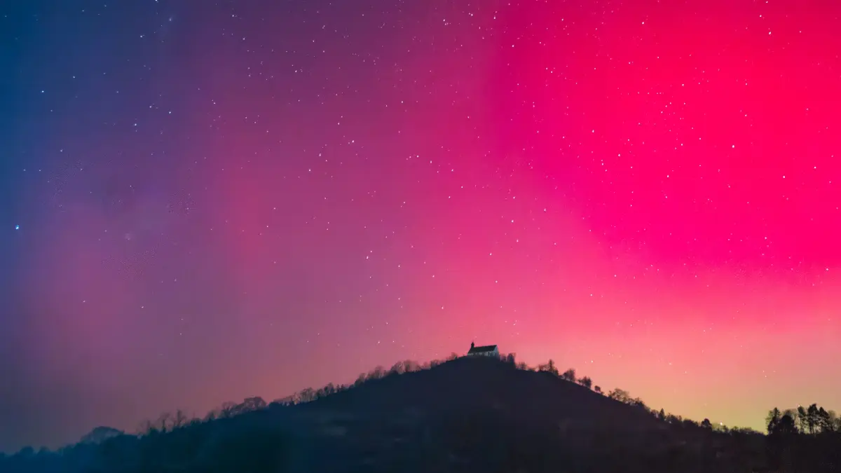 Am Hügel wacht die Kapelle, still und klar, Doch über ihr entbrennt ein fremdes Leuchten Nordisches Feuer, wandernd, mild und kühn Polarlichter weben grüne Pfade.